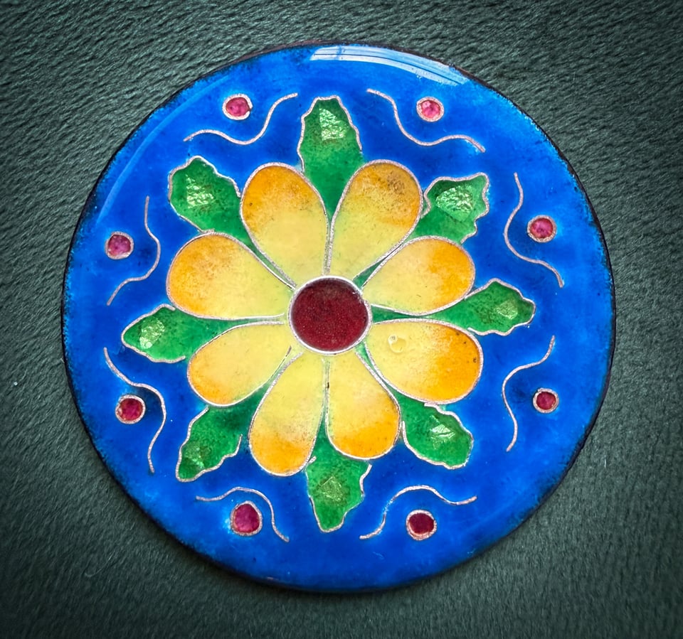 enamel flower on circular metal