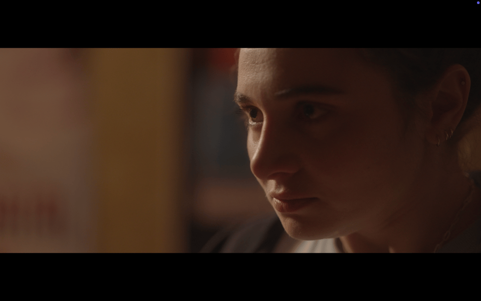 A 3/4 close up of a woman staring intensely ahead of herself