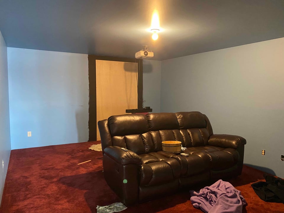 a brown couch sits in a room with blue walls and red carpet