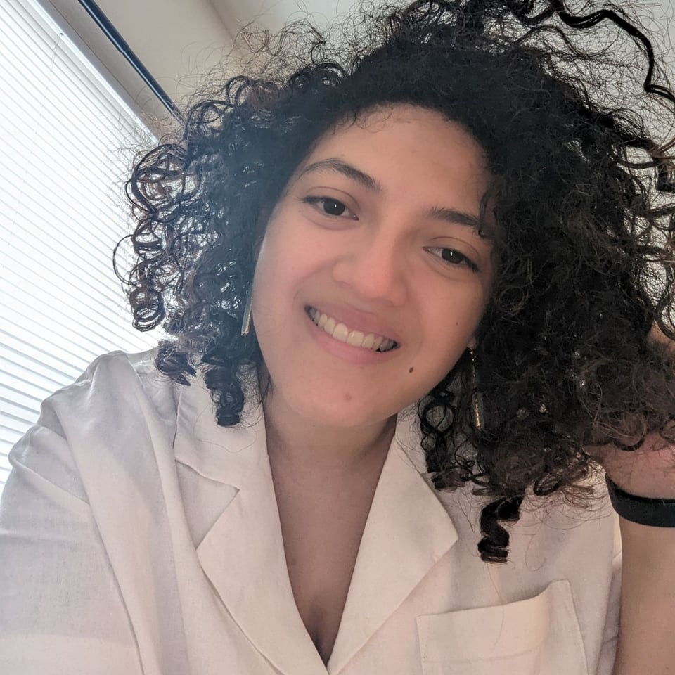 Raquel Sands wearing a white button-down shirt.