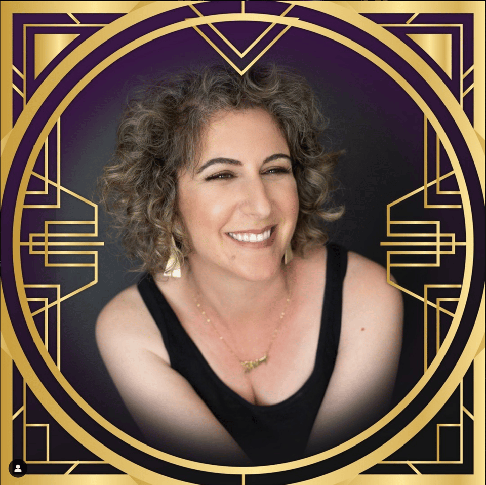 A picture of a smiling woman with an elaborate golden frame.