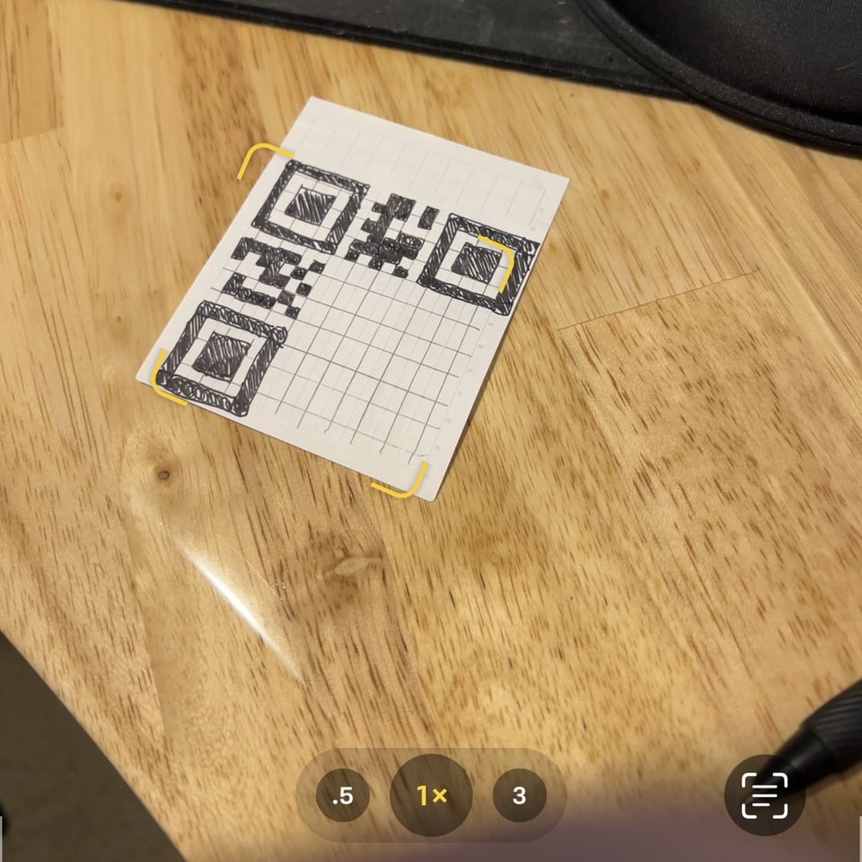 Partially-drawn QR code on a small grid paper sheet