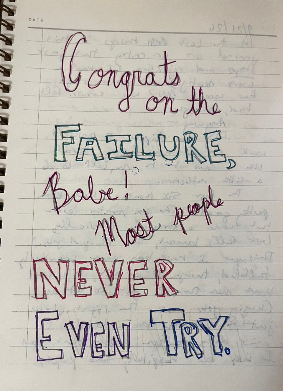 A page from a notebook, which in a combination of awkward block lettering and terrible cursive and a variety of colors reads "Congrats on the FAILURE, babe! Most people NEVER EVEN TRY."