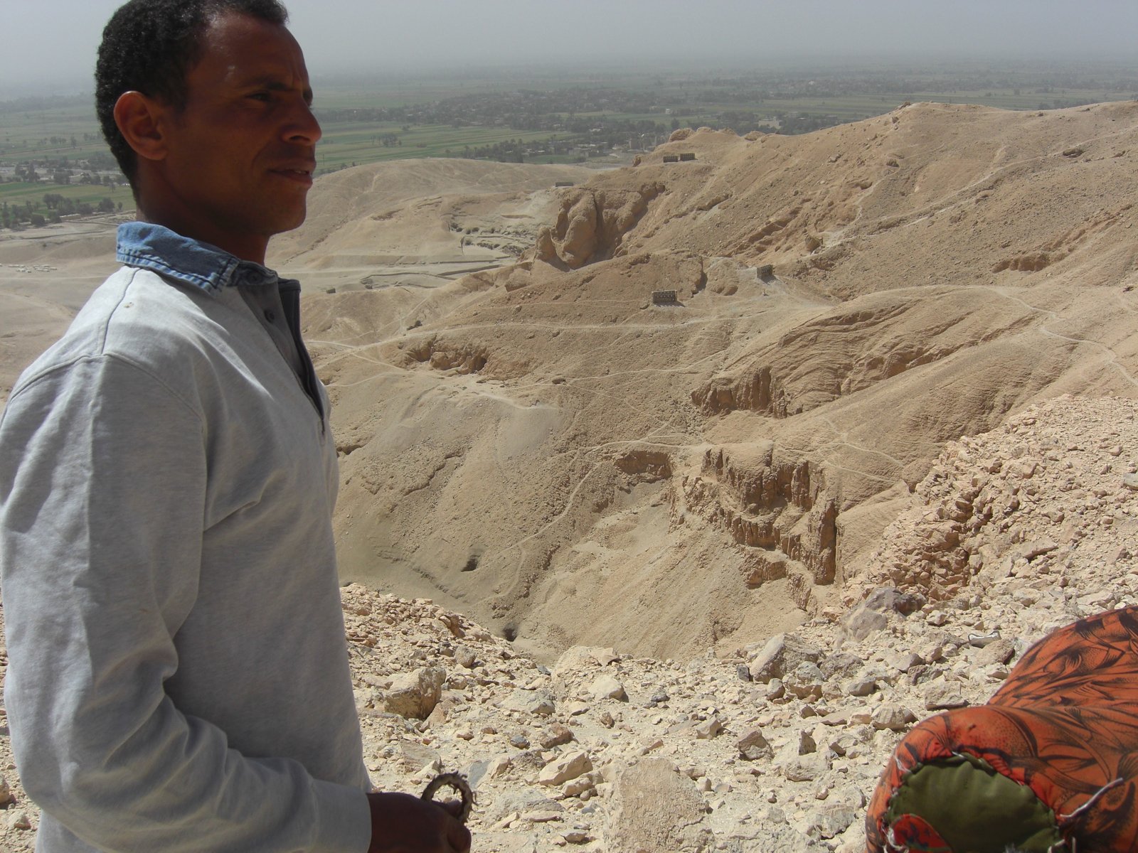Our guide overlooking the Valley of the Kings from the mountaintop, with the green Nile valley visible in the haze beyond