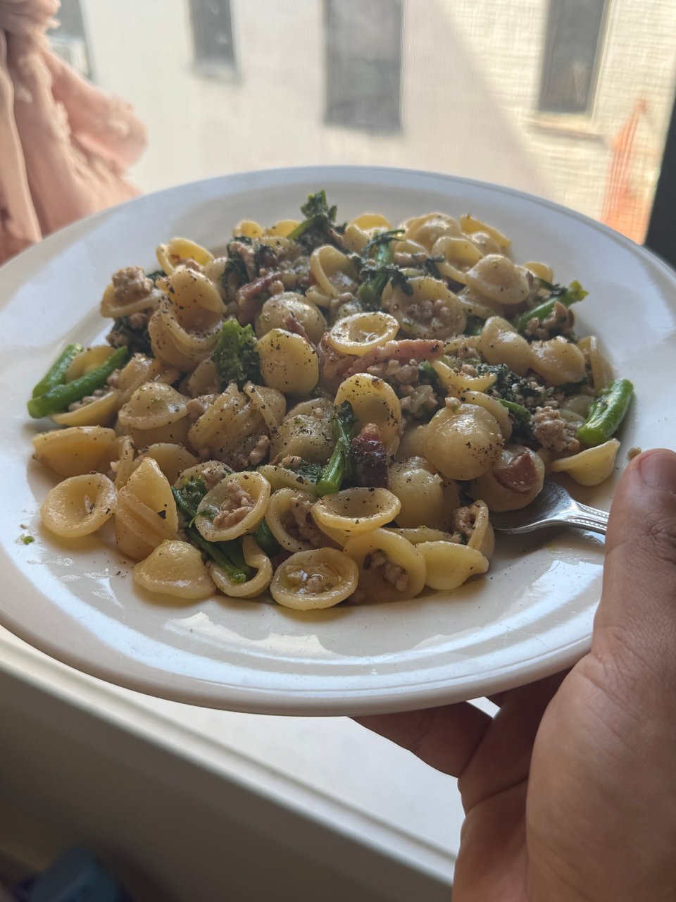 a plate of sausage and orecchiette with broccoli rabe.