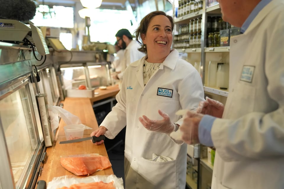 Niki Russ Federman helps NPR host Scott Simon slice paper thin strips of salmon