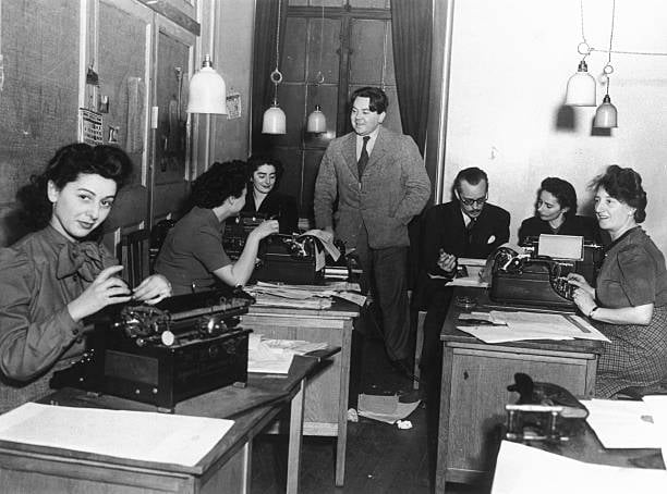 FRANCE - FEBRUARY 23: Radio news department, London, 4 January 1946. Radio news department, London, 4 January 1946. 'London calling Europe. French and Flemish broadcasts to Belgium played an important part during WWII in aiding the resistance movement in Belgium. The broadcasts continued after the war with a view to helping post-war reconstruction and serving as a projection of Britain. Programme assistants and secretaries preparing a French programme. W J Davenport, Programme Organiser of the Belgian Service, standing in background'.