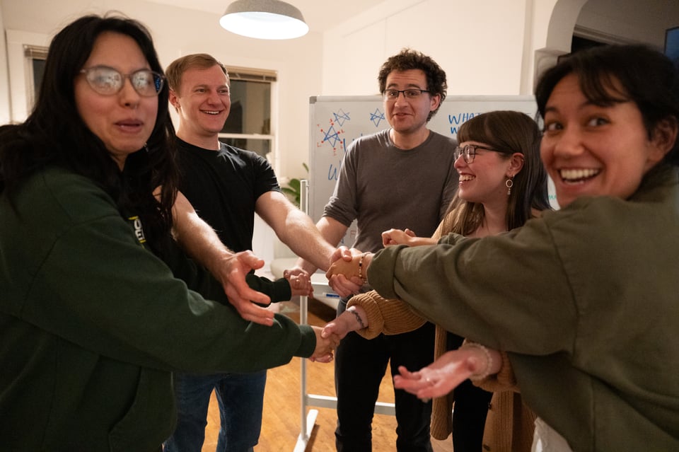 A group of people holding hands, upset with the photographer.