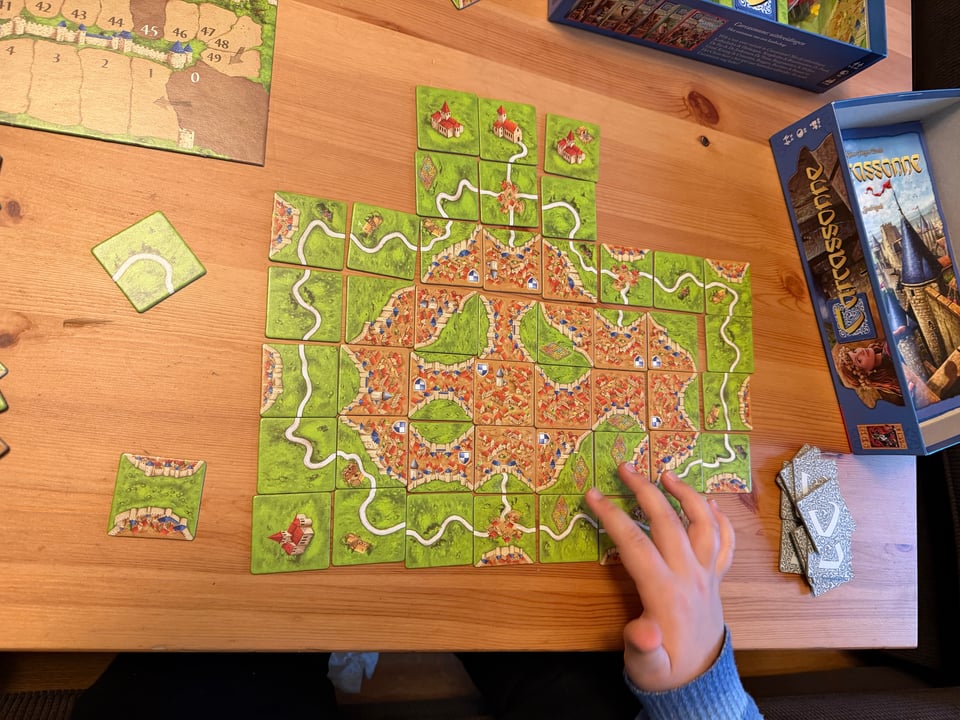 The pieces of a Carcassonne game have been arrranged in one map where all the pieces fit together.