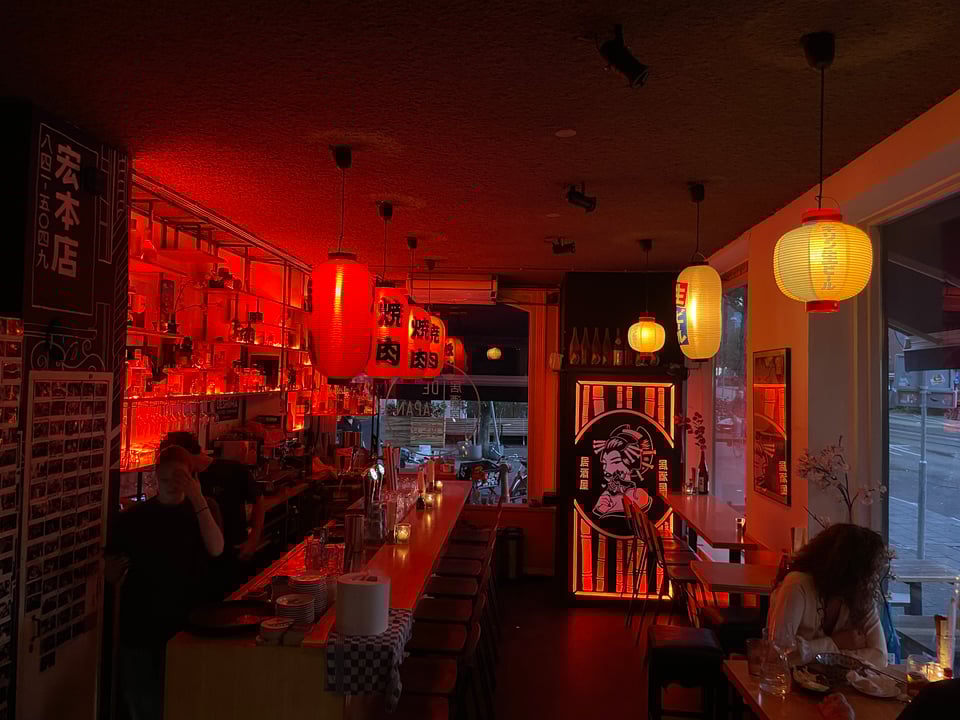 Interior of a restaurant with red lighting.
