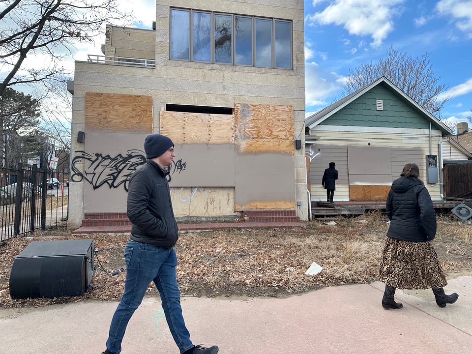 People walking around an abandoned lot.