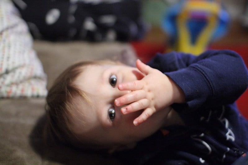 a baby with its hand covering its mouth