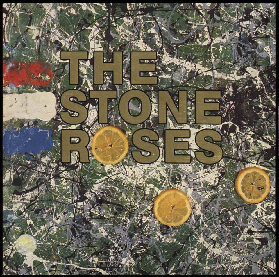 This is a painting in a Jackson Pollock style, of splatters of white and black paint on a dark green background. On the left are three thick strips of paint, one red, one white, one blue. There are three circular slices of an orange or lemon on the canvas as well. THE STONE ROSES in gold lettering is in the center, and one of those slices forms the O of Roses.