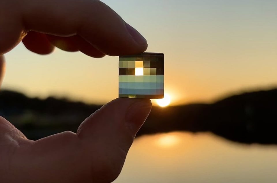 a person holding up a pixel mirror up to a sunset.
