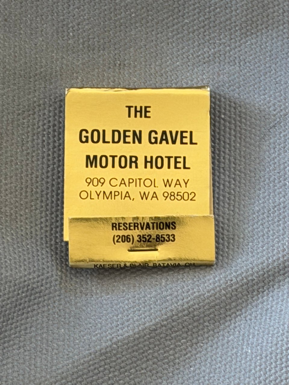 A gold matchbook with text in black that reads
THE GOLDEN GAVEL
MOTOR HOTEL
909 CAPITOL WAY
OLYMPIA, WA 98502
RESERVATIONS
(206) 352-8533