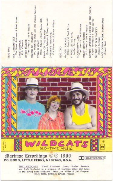 Scan of cassette label - the cover is a photograph of two men and a woman standing in front of a brick wall. The photograph has had color added in kind of a retro surrealist way; around the photograph is an extremely colorful border and hand-written type reading WILDCATS: OLD-TIME MUSIC. There is a back cover with a track listing, as well as a small fold piece that has a label reading Marimac Recordings ©℗ 1988 P.O. BOX 5, LITTLE FERRY, NJ 07643