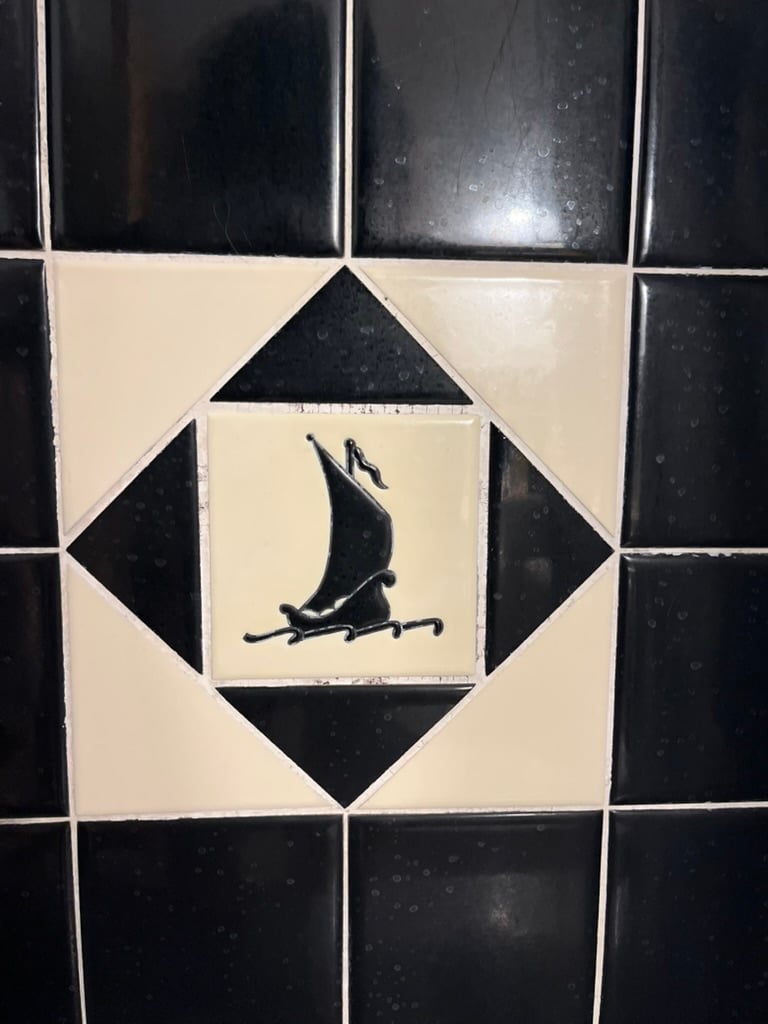 A blue and white bathroom tile depicting a ship at sea