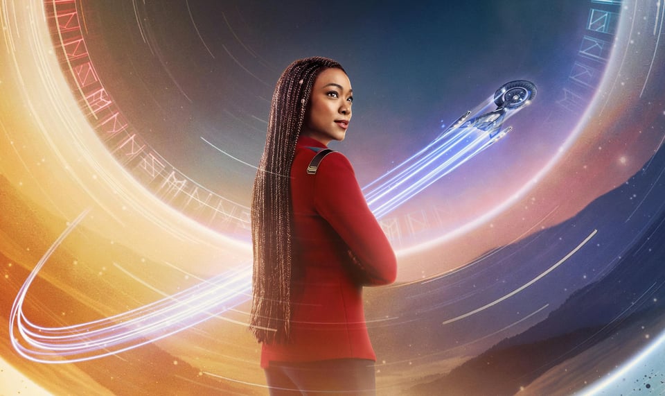 A detail from a poster for season 5 of Discovery, featuring Michael Burnham standing in front of a swirly circle full of weird symbols, with the Discovery zooming around in the background making Space Chemtrails