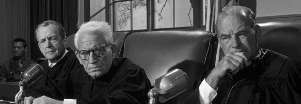 A black and white still of three judges, all of them white, all of them over fifty. This is a still from Judgement at Nuremberg.