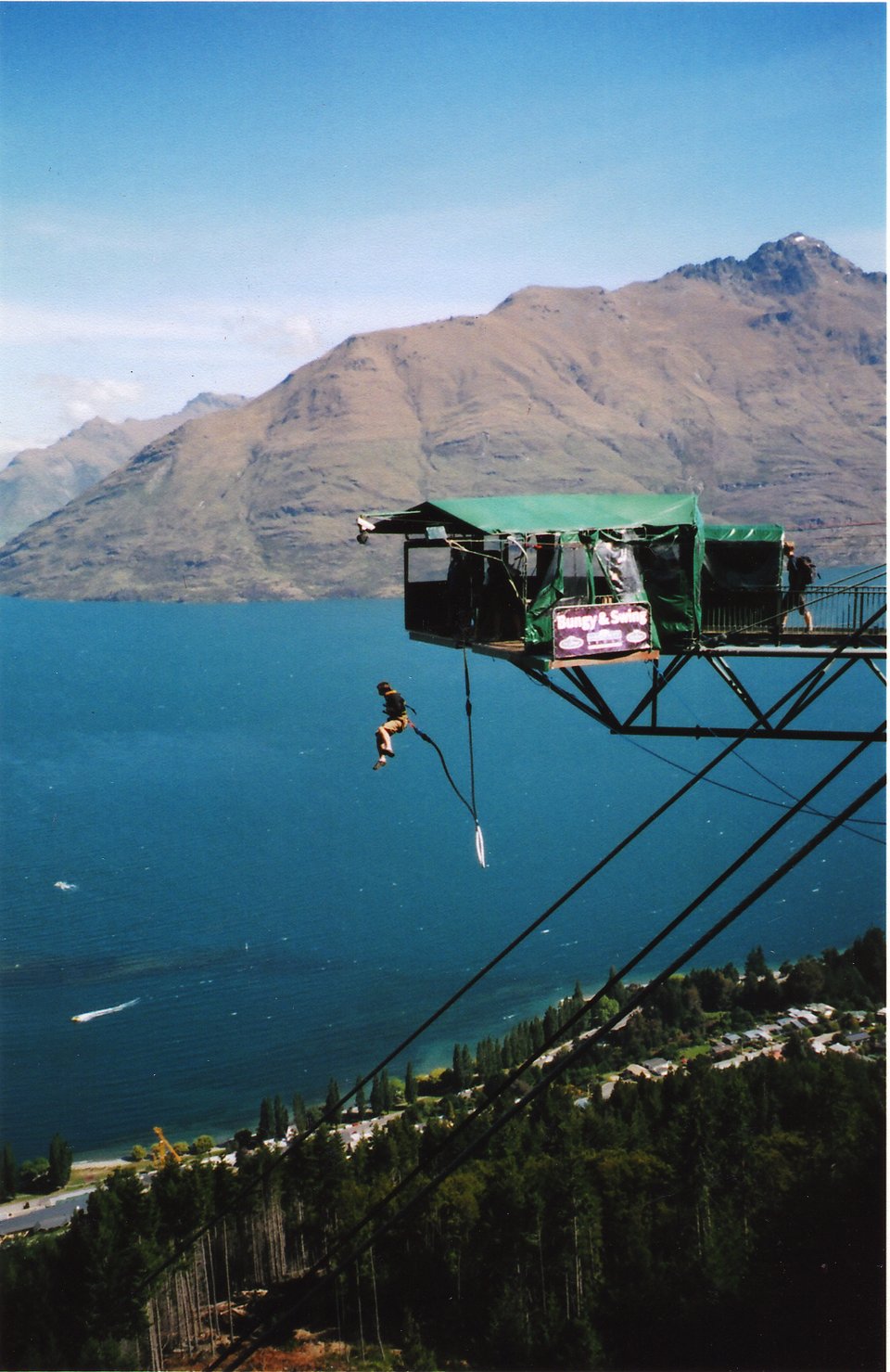 photo of a man bungee-jumping of a platform in Queenstown, NZ. In the background is Lake Wakatipu & mountains