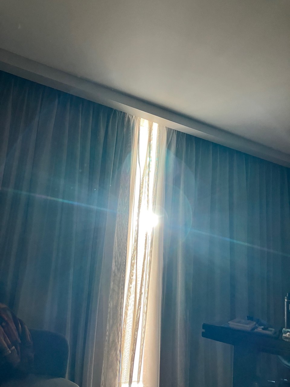 Sunlight comes through a gap in hotel room curtains.