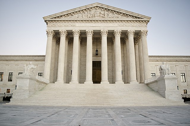 Image of the Supreme Court, a stark neo-classical marble building, with rows of pillars holding up a triangular roof, like a Greek temple. By Jesse Collins - Imported from 500px (archived version) by the Archive Team. (detail page), CC BY 3.0, https://commons.wikimedia.org/w/index.php?curid=71470659