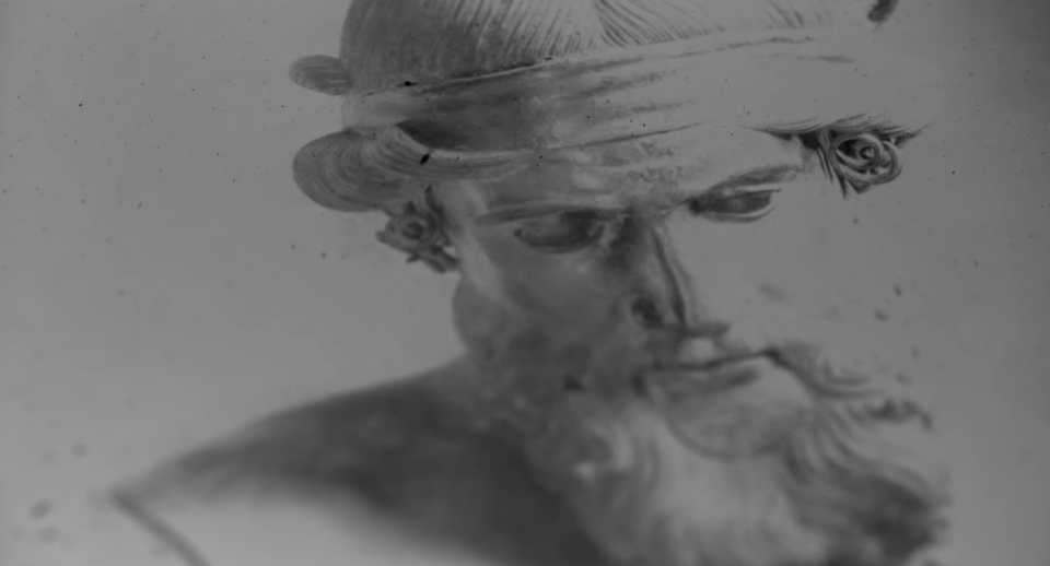 still from Below the Clouds, we see a photo of a bearded ancient statue