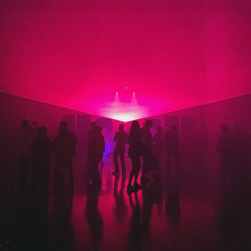 people vibing in the red / purple light of the laser lit dance floor