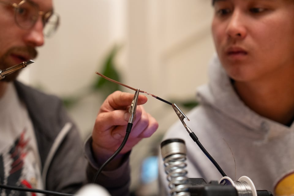 Elijah showing people how to use a soldering iron.