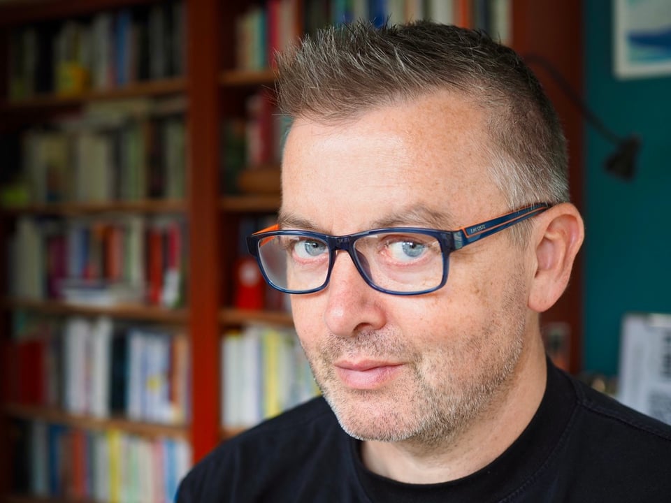 John V Willshire, wearing glasses.