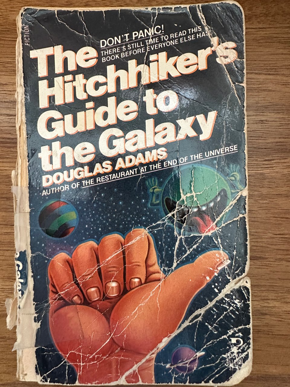 Photo of a mass market paperback version of Douglas Adams' novel The Hitchhiker's Guide To The Galaxy, tattered beyond belief