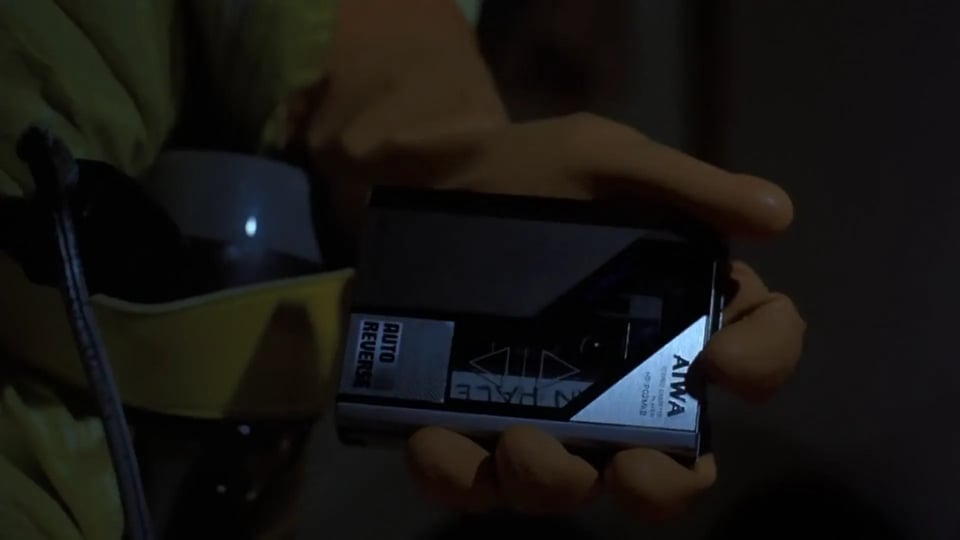 Marty, wearing a radiation suit, presses play on an Aiwa portable cassette player.