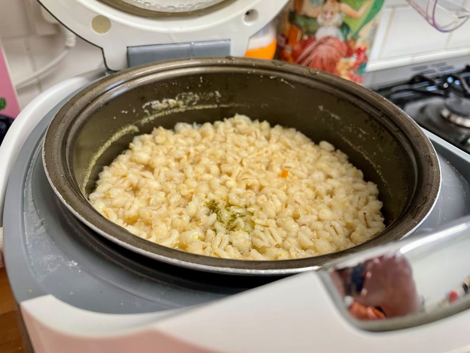 A n open rice cooker with cooked pearl barley inside.