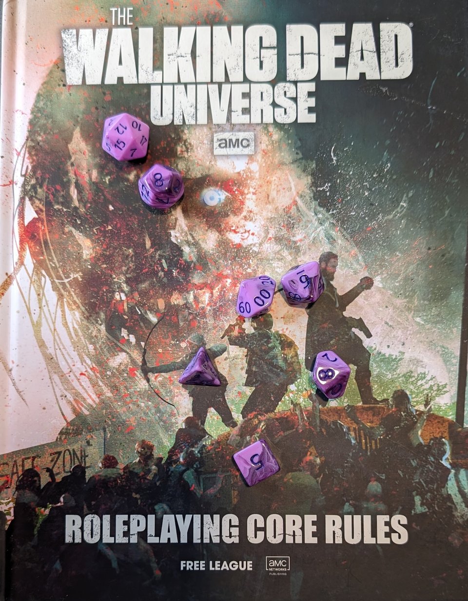 The book for the new Walking Dead roleplaying game from Free League. A set of purple polyhedral dice sit atop the cover.