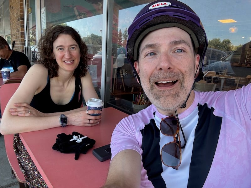 a man and woman taking a selfie at a coffee shop