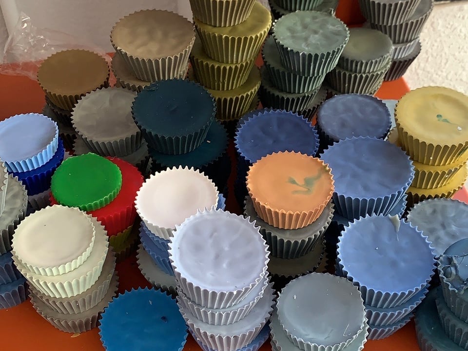 A bunch of stacked wax cups that look like Reese's Cups, but in various colors.