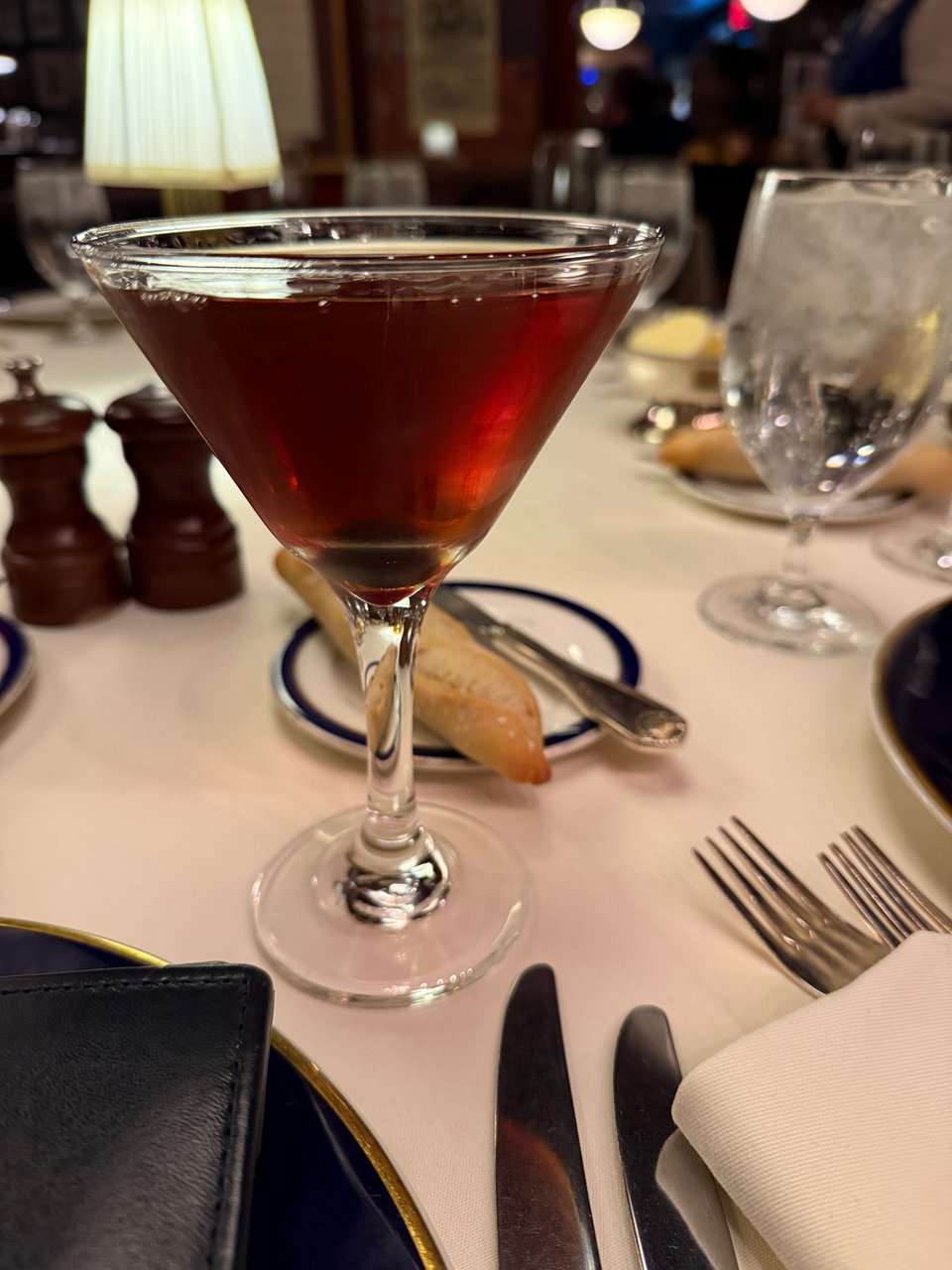 Large Manhattan cocktail in cone-shaped Martini glass on the table at the Lotos Club, New York City