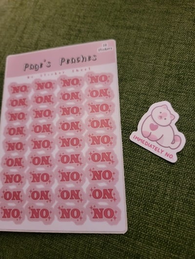 Sheet of pink stickers that say the word “no” next to a single sticker of a pink and white cat that has the text “Immediately No” under it.