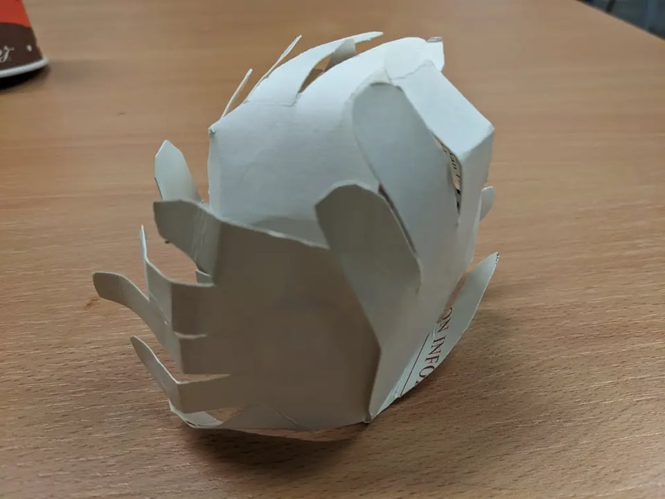 A sculpture made out of hands cut out of paper.