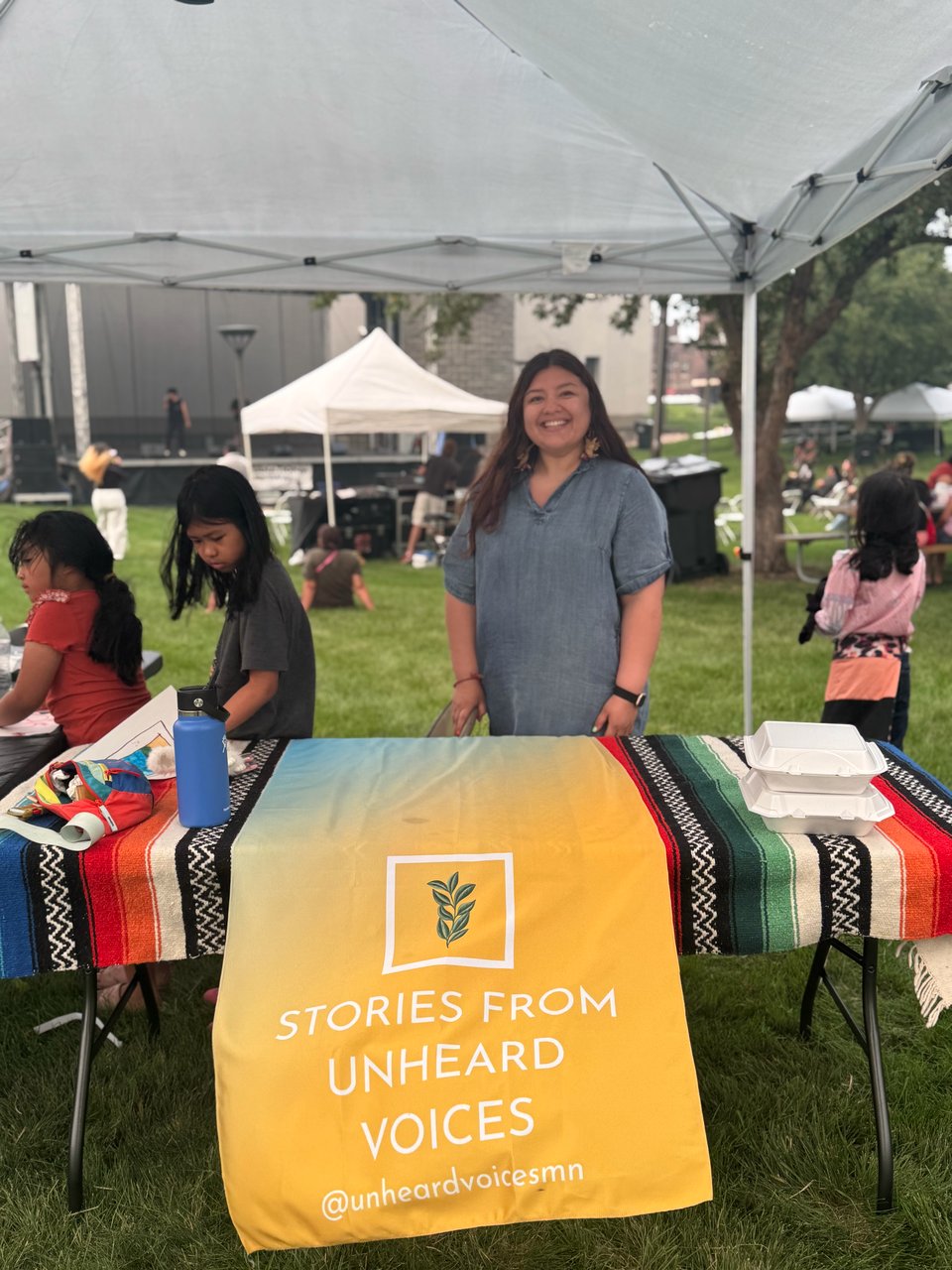 an image of myself standing near my booth at the international festival 2025 in worthington, minnesota