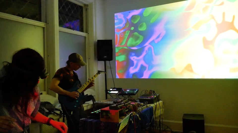 people playing music and visuals in an art space