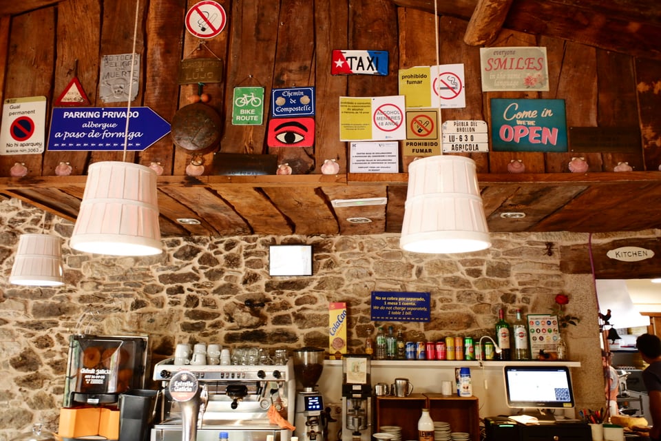 An array of signs and posters in a remote cafe near Palais de Rei