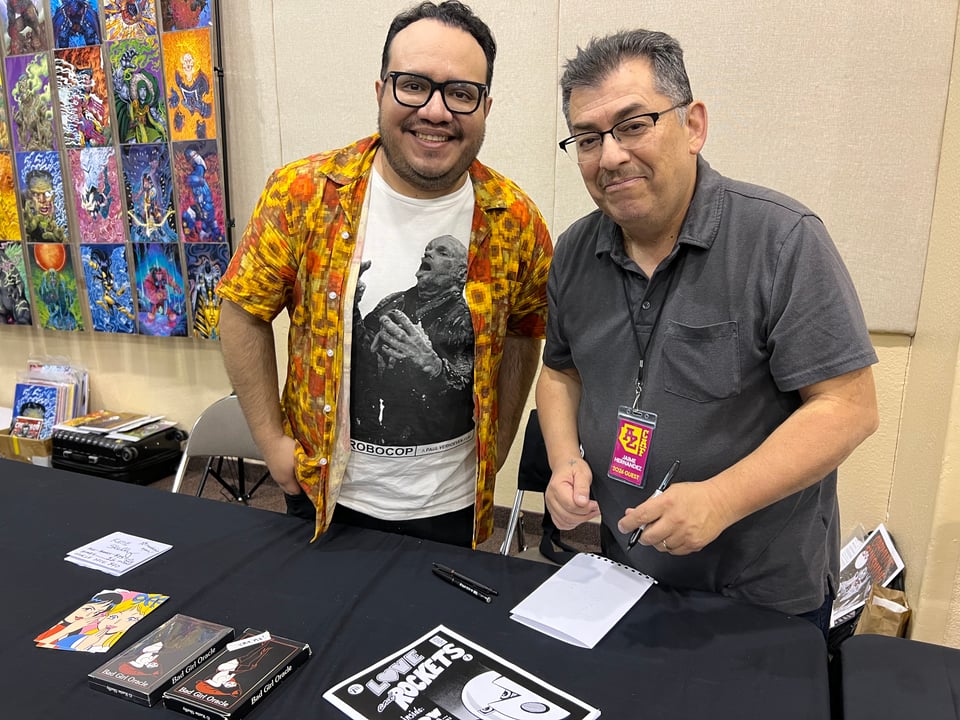 henry and xamie behind a comic con table