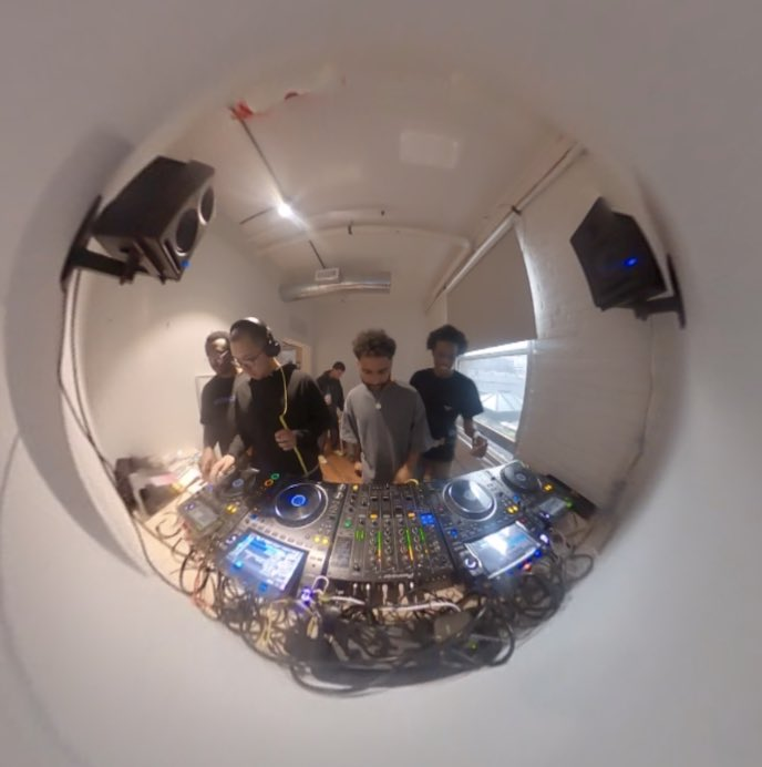 A fisheye image of Yatú DJing with friends.