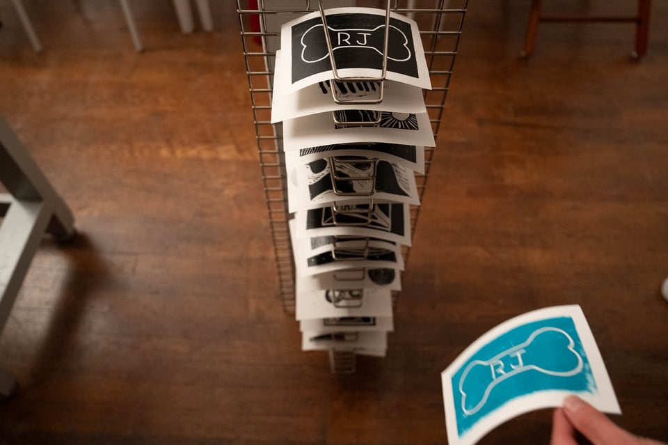 A stack of prints in a drying rack.