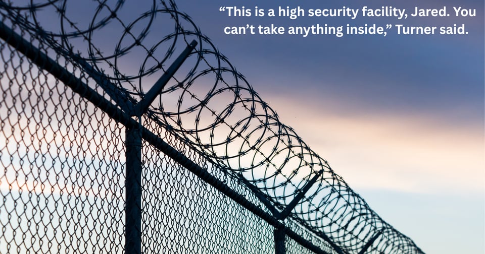A fence topped with barbed wire. Text says "This is a high security facility, Jared. You can't take anything inside."