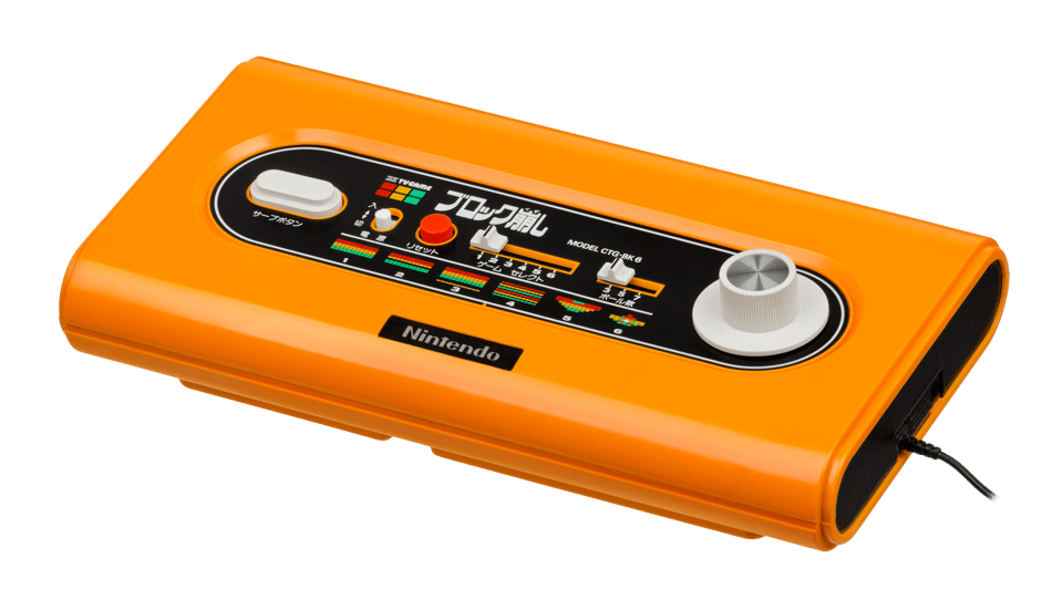 An orange home videogame console with light grey knobs and some buttons and sliders in the middle.