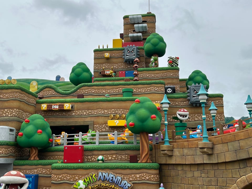 View of Nintendo Park showing trees, buildings, and characters from the Mario franchise