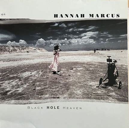 A wide landscape shot of a flat dusty desert, with a hill in the background on the left and white fluffy clouds in the broad blue sky. In the center, a little distance from the camera, is a woman in a flowing pink dress. On the right and closer to the foreground is some kind of wheeled machine? Maybe like a portable oxygen tank? I’m not entirely sure what it is.