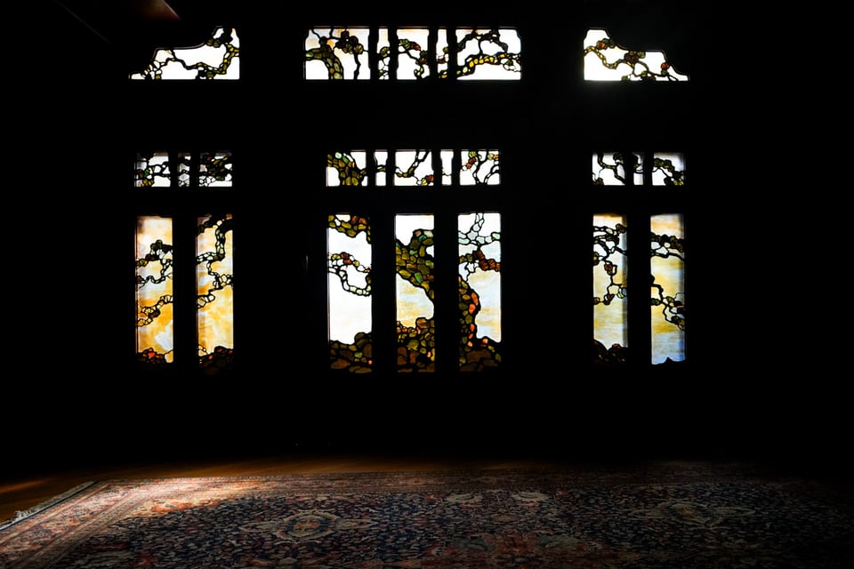 a stained glass tree stretches across a wall in sections